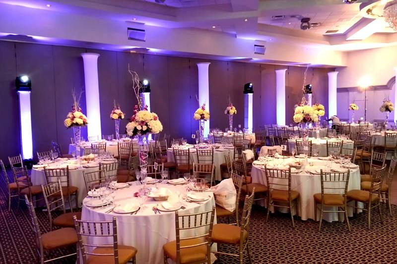 Toronto wedding reception room set with white linens, floral centrepieces and architectural uplighting before guests arrive
